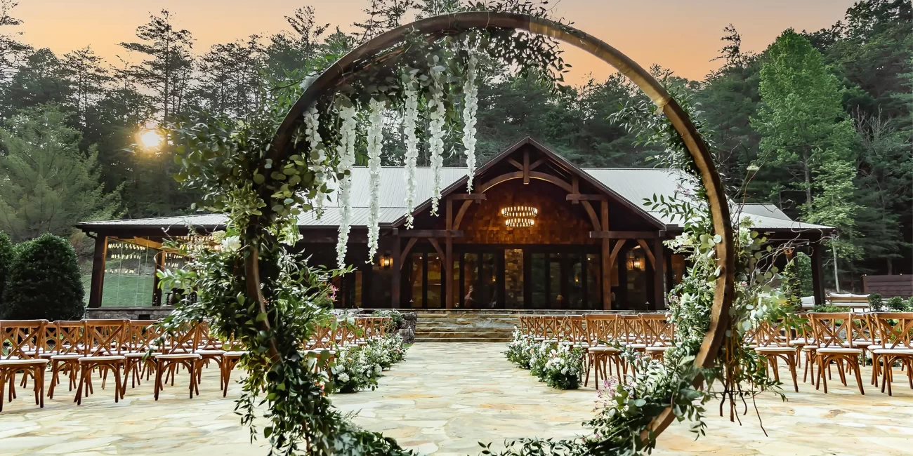 Outdoor ceremony setup, framed by lush florals & sunset light